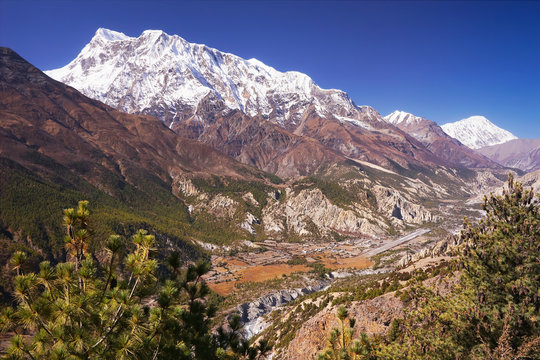 Nepalese village on Manang in the valley of Marsyangdi river, Humde airport, Annapurna III mountain summit on background, Annapurna Circuit Trek, Himalaya, Nepal, Asia. horizontal view
