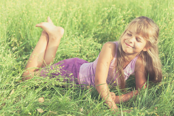 Naklejka na ściany i meble Happy little girl playing in park.