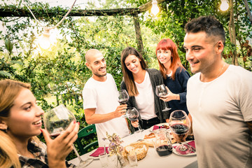 Happy friends having fun drinking red wine at backyard garden party - Youth and friendship concept...
