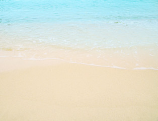 Naklejka na ściany i meble Soft wave of blue ocean on sandy beach. Background.