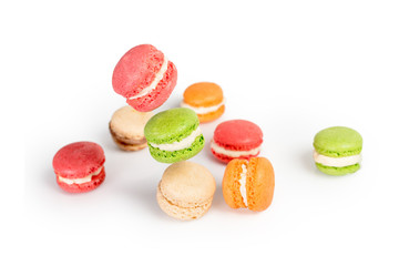 Different types of macaroons in motion falling or flying on white background. Traditional french dessert isolated