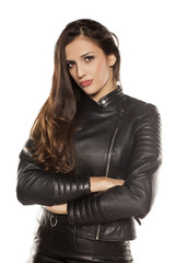 young beautiful woman in leather jacket on white background