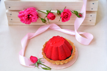 Air and red cake with chocolate near pink ribbon, rose on foreground