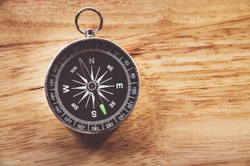 compass on wooden background with space for text