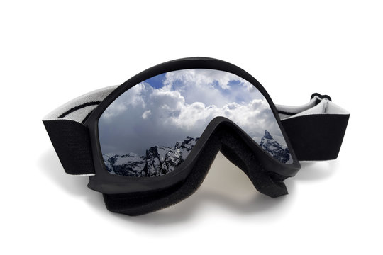 Ski goggles with reflection of winter snow mountains