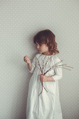 kid girl in nightgown retro with sprigs of willow