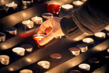 Lighting a candle for someone - Votive church candles in rows - Powered by Adobe