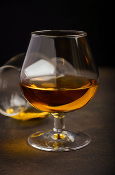 Glass of brandy or cognac on the old rusty background