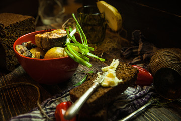 grilled salmon steak with potatoes, leak, peppers, butter on wooden table with napkin and fork