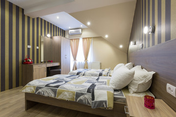 Interior of a new hotel double bed bedroom in the attic
