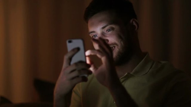 happy young man with smartphone at night