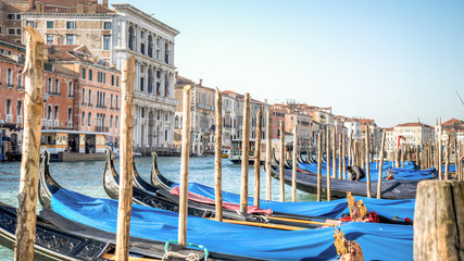 Venice, Italy - February 17, 2015:  Classical picture of the venetian canals with gondola across the canal.