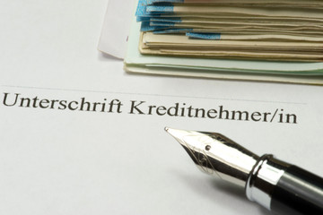 Ein Kreditvertrag, Füllfederhalter und Euro Geldscheine