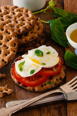 Healthy Swedish crackers with tomato, mozzarella cheese and basil leaves.