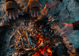 People on the nature of fried bacon on the fire and warm hands