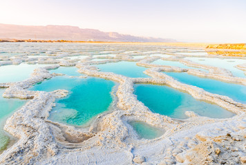 View of Dead Sea coastline. Salt crystals at sunset. Texture of Dead sea. Salty sea shore