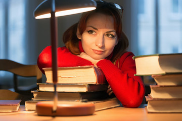 girl reading a book in the library under the lamp