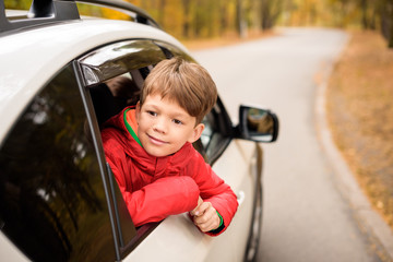 Smiling boy looking through car window