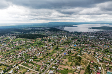 Obraz premium Urban panorama aerial view. City surrounded by forest