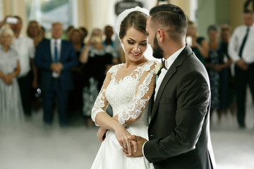 Groom holds bride carefully dancing in the smoke