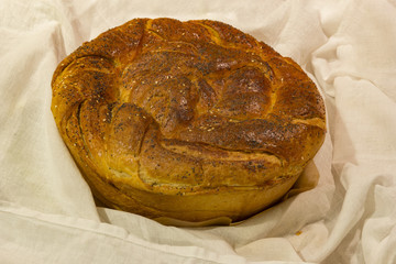 fresh baked round loaf of bread on white cloth