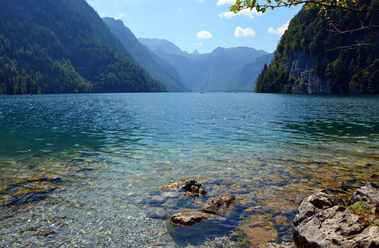 Waterside with crystal clear water at K&ouml;nigssee on a sunny summer day