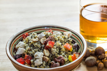 Christmas kutia and uzvar. Traditional ukrainian cereal wheat porridge with raisins, nuts, poppy seeds, honey and candied fruit in earthenware bowl with dried fruit drink on natural wood table