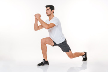Full length portrait of a fitness man doing squats exercises