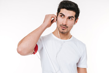 Portrait of a young sports man with earphones looking away