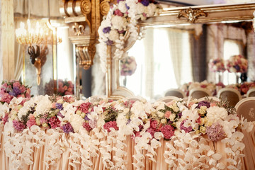 White orchids hang from flower garland of pink and white hydrang