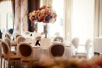 Daylight illuminates grey chairs standing around tables prepared