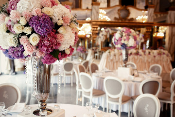 Fototapeta na wymiar Large pink bouquet of hydrangeas and roses stands on dinner tabl