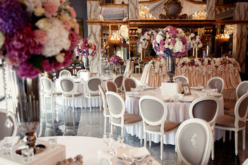 Large pink bouquet of hydrangeas and roses stands on dinner tabl