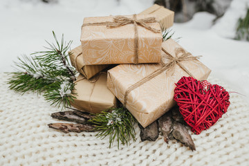 The Valentines day concept. Valentines gifts, vintage romantic red heart gifts boxes, tree branches and bark of tree lie on a woolen blanket background. Winter theme. Top view.
