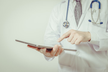 Doctor using a digital tablet on white background , vintage