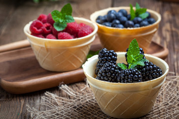 Blackberries, raspberries and blueberries in a waffle bowls.