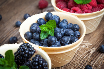 Blackberries, raspberries and blueberries in a waffle bowls.