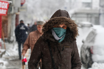 Bucharest, Romania, December 29, 2014: A woman walks on the street during a blizzard in Bucharest.