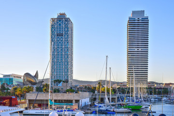 Skyscrapers towering over the marina in Port Olympic Harbor , Barcelona, Spain at sunset