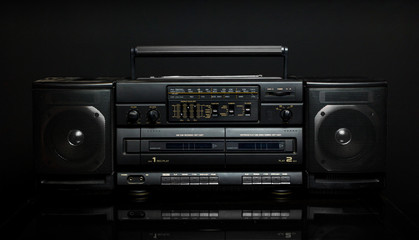 Vintage boom box on black background © nehopelon