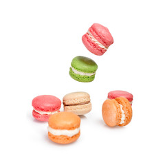 Different types of macaroons in motion falling or flying on white background. Traditional french dessert macarons isolated