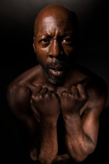 Fototapeta na wymiar Black man with clenched fists and suffering in emotional pain,