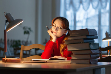 girl reading a book in the library under the lamp