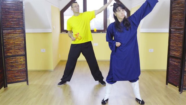 Teacher and learner together practice forms of shaolin martial arts indoors 4K 
