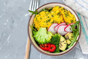 A bowl with a simple vegetable salad (Broccoli, avocado, radish and lentil burgers)