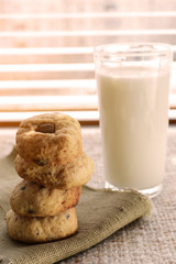Glass transparent cup with milk and chocolate chip cookies standing at the window.
