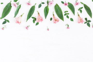 Flowers composition. Border made of pink flowers and leaves. Top view, flat lay