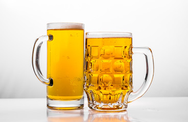 Two Mugs of fresh beer with cap foam
