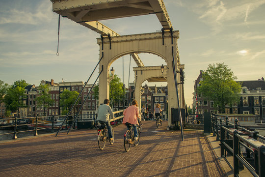 People on bicycle by bridge over Amsterdam