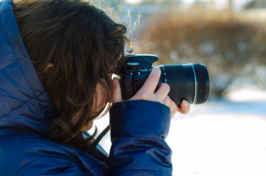 Young woman taking photo outdoor on winter
